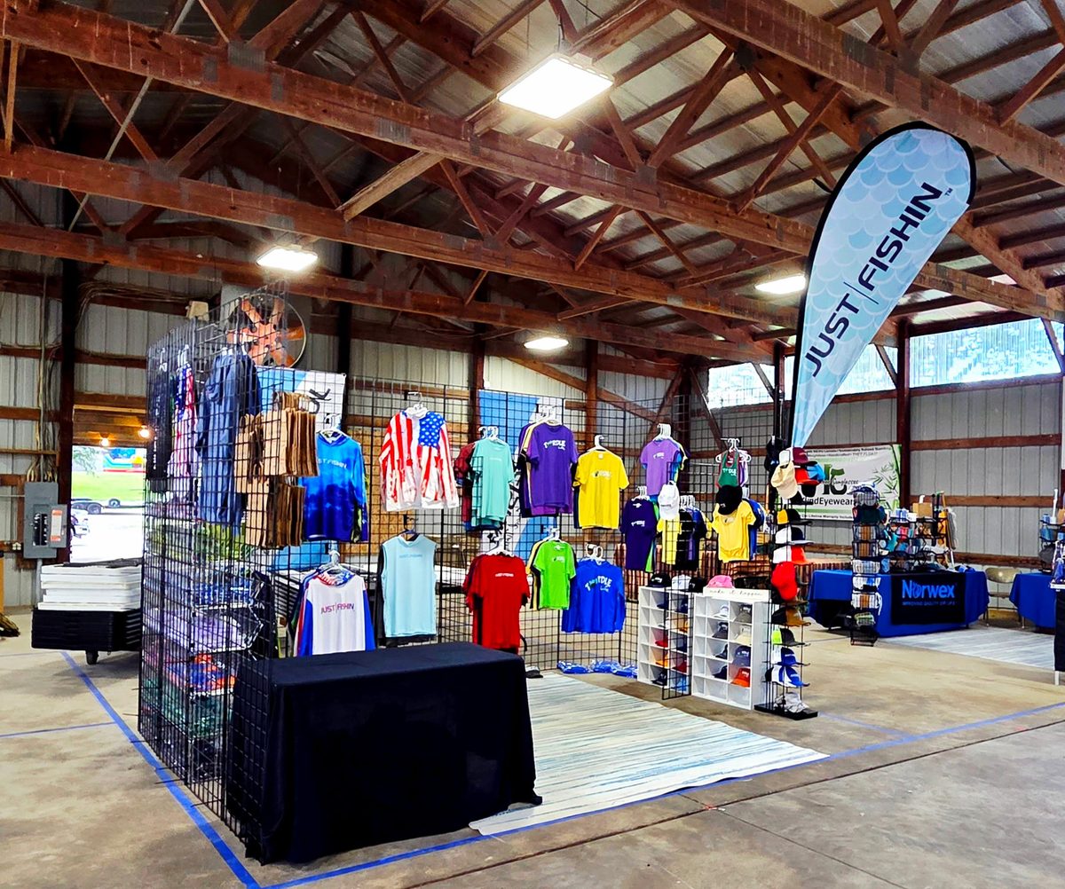 Big Dawg Brands booth on a trade-show floor: Just Fishin' banner and apparel wall